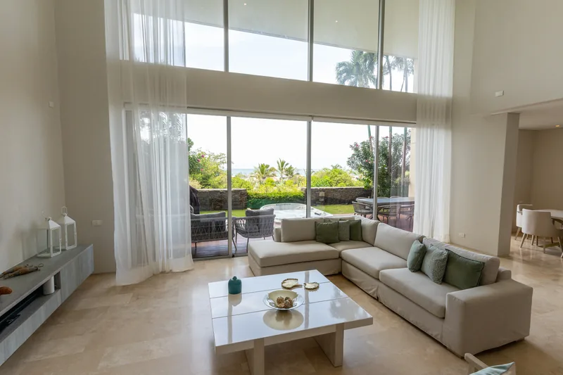 Sala dúplex de doble altura con gran ventanal hacia la terraza.